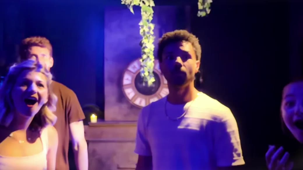 Players reacting with excitement inside the blue-lit Tears of Freya escape room